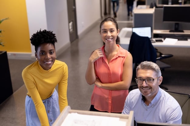 A diverse group of employees collaborating on a project in a modern, open-plan office. The atmosphere is positive and supportive, with smiles and engaged expressions visible.