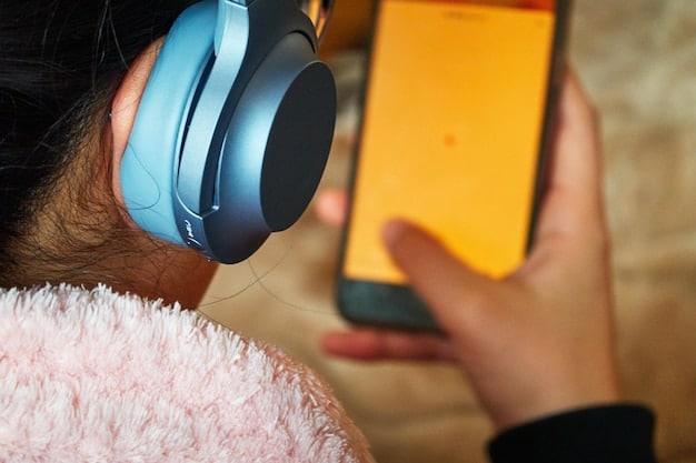 A close-up shot of a smartphone displaying a music streaming app interface, showing various curated playlists and new releases. The interface features bright colors and user-friendly navigation.