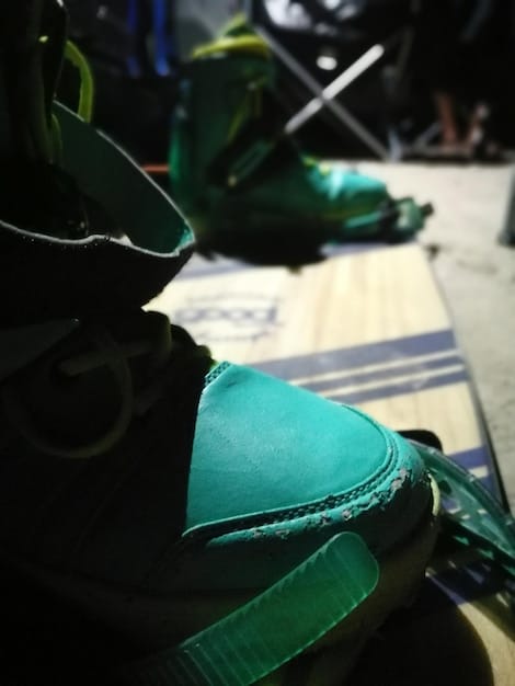 A split-screen image comparing an older, traditional running shoe with a modern, technologically advanced marathon shoe, highlighting the differences in materials, design, and overall construction.