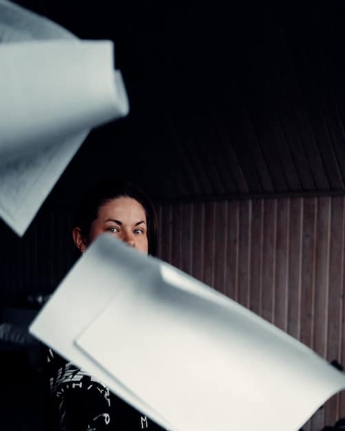 A silhouette of a filmmaker contemplating a stack of legal documents and contracts, with a focused expression, representing the burden of navigating legal complexities, set against a backdrop of a projection screen displaying abstract legal graphics.